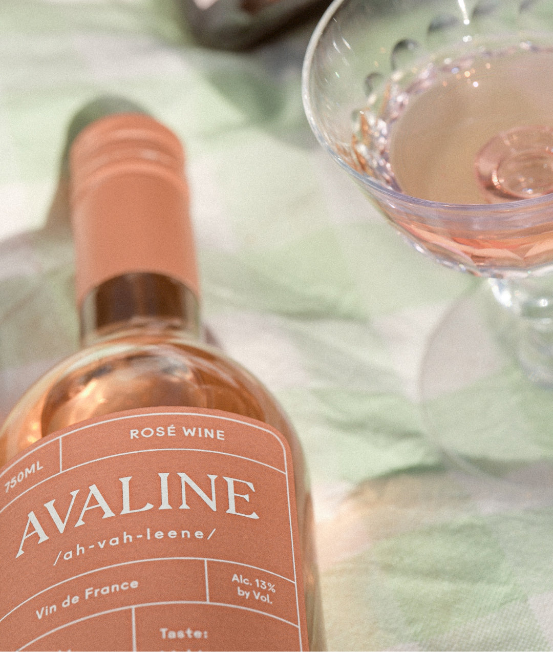 Bottle of avaline rose next to a full glass