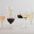 Image of multiple glasses of various wines on a white table
