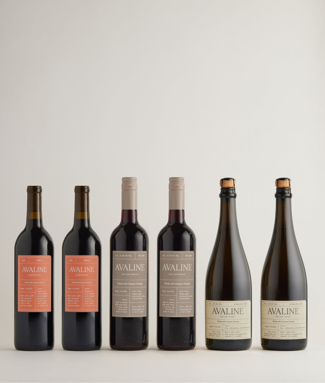 A lineup of 6 wine bottles including 2 merlot, 2 red, 2 sparkling